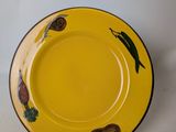 a yellow plate with a design on it on a white surface