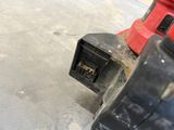 a close up of a red and black corded drill