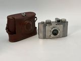 two cameras sitting next to each other on a white surface