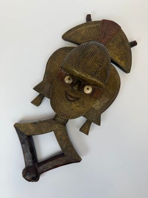 une image d'un masque en bois accroché au mur