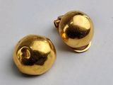 paire de boucles d'oreilles en forme de boule plaquées or sur un fond blanc