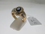 Gros plan sur une bague en or ornée d'une pierre noire