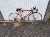 un vélo rouge appuyé contre un mur blanc