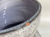 a close up of a gray vase with a white background