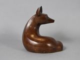 an image of a wooden sculpture of a dog on a gray background