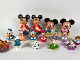 Des figurines de Mickey Mouse et de ses amis sont alignées sur une surface blanche