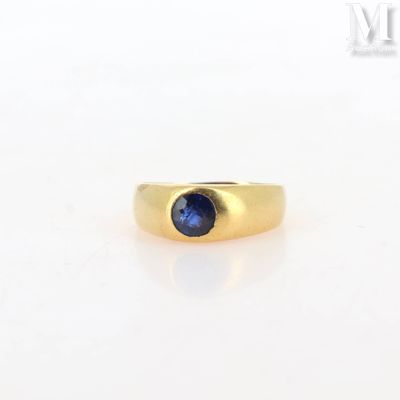 a close up of a gold ring with a blue sapphire stone