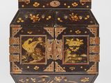a black and gold box with birds and flowers on it