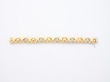 a yellow gold bracelet with diamonds on a white background
