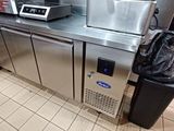 une cuisine avec tout un tas d'appareils électroménagers et un sac poubelle posé sur le plan de travail