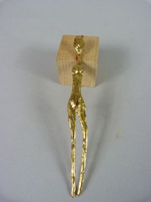 une figurine en or posée sur une table blanche