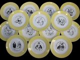 yellow and white plates with black drawings on them on a black background