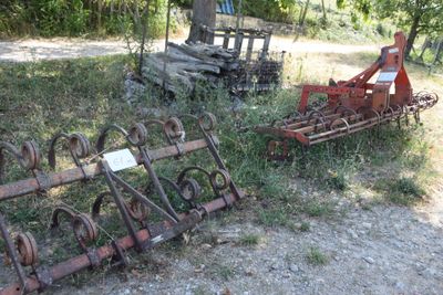 many old farm implements that are sitting in the grass