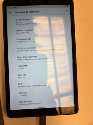 une tablette posée sur une table, avec l'ombre d'une personne