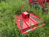 une machine rouge qui est garée dans l'herbe