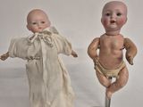 two dolls that are standing next to each other