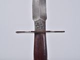 a knife that is sitting on top of a wooden stand