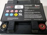 un gros plan d'un boîtier de batterie noir muni d'un bouton d'arrêt rouge