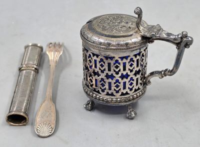 une théière en argent, avec une cuillère et un repose-cuillère à côté