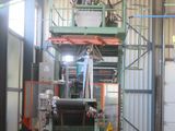 a picture of a machine in a factory with a bucket on the back of it