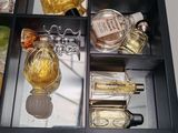 a glass display case filled with perfumes and perfume bottles