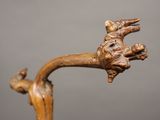 a close up of a wooden sculpture of a bird on a branch