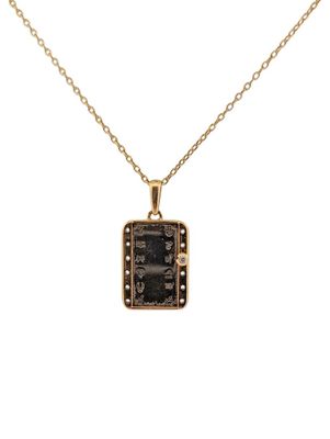 a gold plated necklace with a black stone pendant on a chain