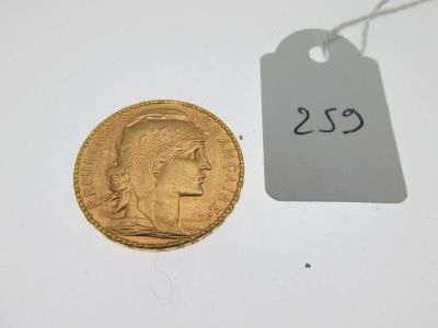 un gros plan d'une pièce d'or à côté d'une étiquette de prix