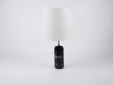 une lampe en marbre noir avec un abat-jour blanc sur fond blanc