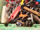 many different tools in a green basket on the table