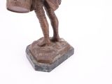 statue of a man holding a bucket and a bag on top of a base