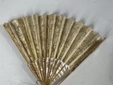 a gold fan that is on the wall next to a white wall