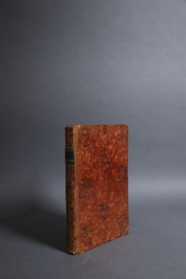 an old book sitting on top of a gray surface