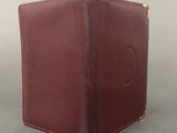 brown leather wallet with a round logo on the front