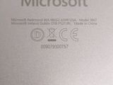 the back side of a silver laptop with the microsoft logo on it