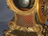a gold clock that is sitting on top of a table