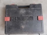 a black tool box with a red handle on the floor