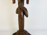 une image représentant une statue en bois d'une femme tenant un oiseau