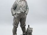 statue en bronze représentant un garçon avec un chien, posée sur un socle en marbre