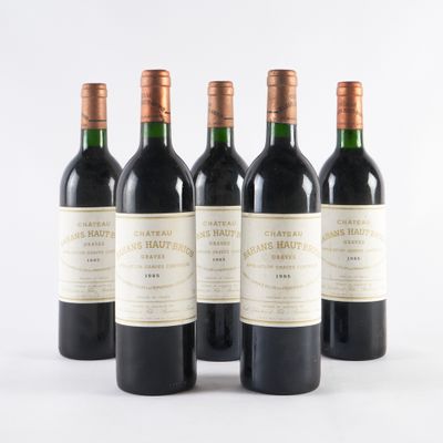 quatre bouteilles de vin sont alignées sur une surface blanche