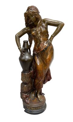 bronze statue of a woman with a vase on a pedestal