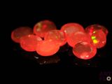 des perles de verre rouge vif sur un fond noir