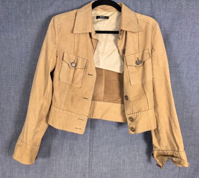 une veste beige suspendue à un cintre sur un mur bleu
