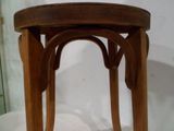 un tabouret en bois avec une assise en bois posé sur une surface blanche