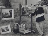 photographie en noir et blanc d'un homme debout devant un chevalet de peinture