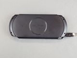 a black cell phone that is connected to a charger