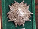 une médaille d'argent et un livre posés sur une table en bois