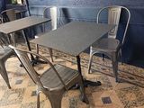 a table and chairs in a restaurant with a blue wall