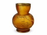 un vase jaune orné d'une inscription, posé sur une table