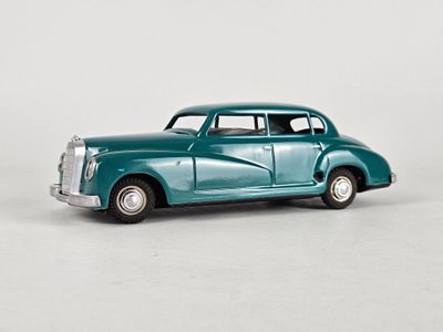 an old model of a blue car on a white surface